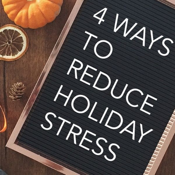 Felt letter board titled "4 Ways to Reduce Holiday Stress" next to dried orange slices, a pumpkin, and pinecones