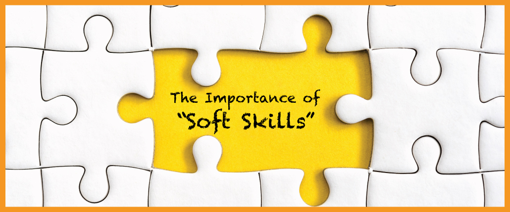 May Blog header image of white puzzle pieces with the middle one middle and the title over "The Importance of 'Soft Skills'"