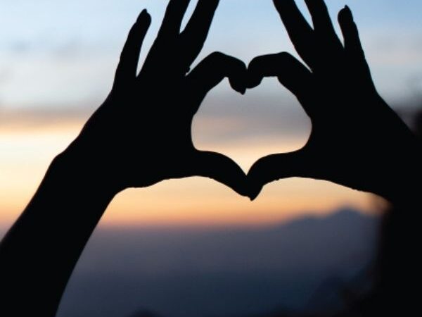 October 2020 blog feature image of two hands making a heart shape with a sunset in the background