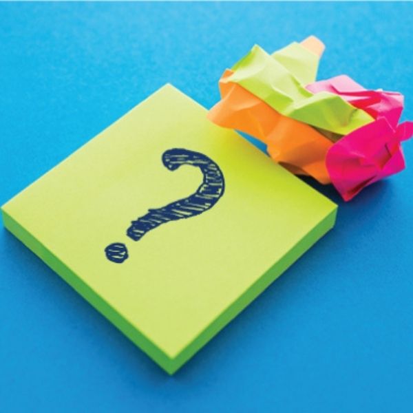 Green post-it note with a "?" drawn on it with a ball of crumpled-up post-it notes