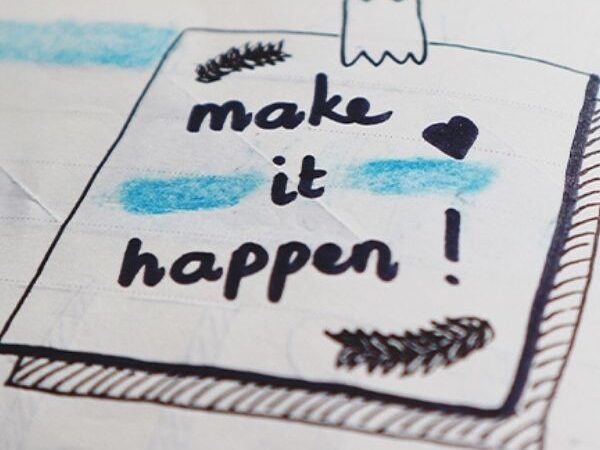 planner open to a doddle of drawing that says "Make it Happen!" with blue highlights