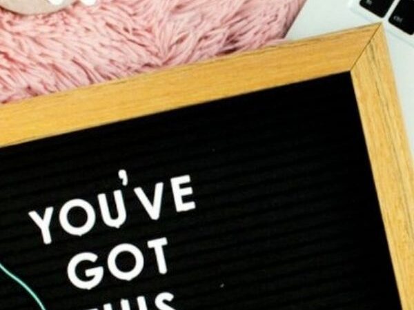 close up of a felt board sign that reads "You've Got This" on top of a laptop and pink rug