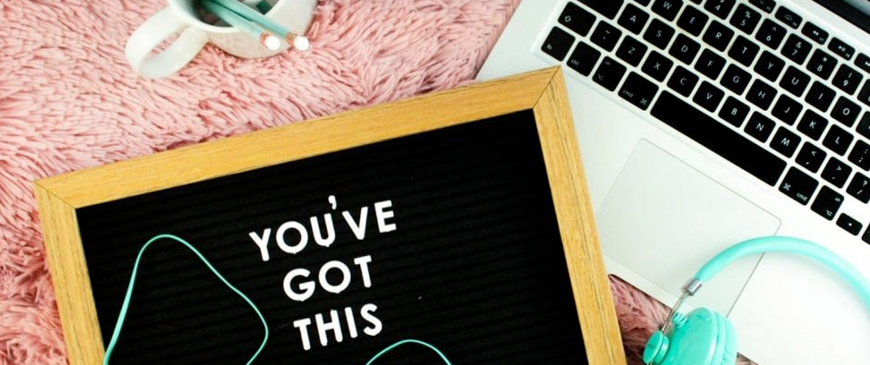 close up of a felt board sign that reads "You've Got This" on top of a laptop and pink rug