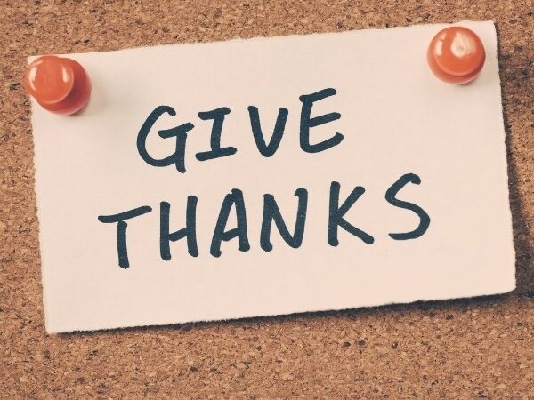 note pinned on cork board with "Give Thanks" written on it