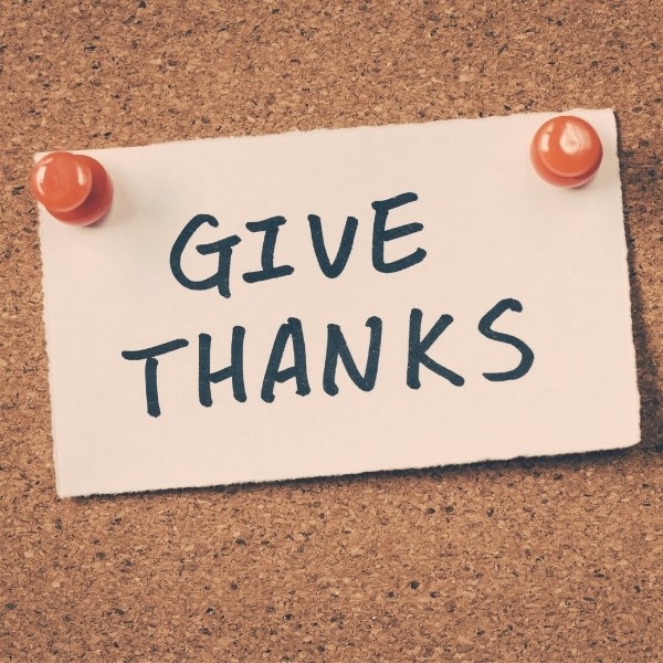 note pinned on cork board with "Give Thanks" written on it