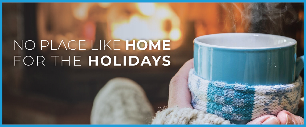 Dec blog header image of two hands holding a mug with steam, in front of a lit fireplace with the text overlay of "No Place Like Home For the Holidays"
